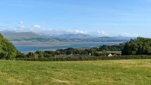 a view of a lake with mountains in the distance at Llinos Cottage in Beaumaris +1 photo