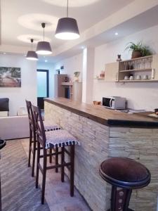 a kitchen with a bar with two chairs and a table at Apartments Beka in Žabljak