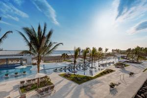 an aerial view of a resort with a pool and palm trees at Oceana Resort & Conventions in Monterrico