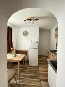 eine Küche und ein Esszimmer mit einem Tisch und einem Kühlschrank in der Unterkunft La Mary in Old Town in Sibiu