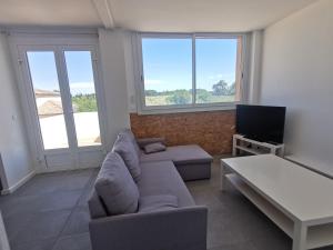 a living room with a couch and a tv at La Dolce Vita aux portes de Montpellier in Villeneuve-lès-Maguelonne