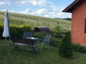 un banco, una mesa y una sombrilla en un patio en Haus Willi en Aßlar