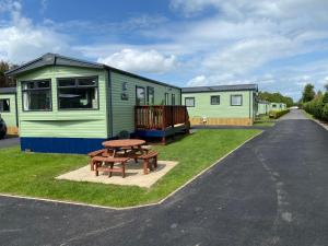 a picnic table and a bench in front of a caravan at The Sanctuary Holiday Home - Escape the Ordinary in Knaresborough