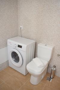 a bathroom with a washing machine and a toilet at CASA CANTICO in Margarítai