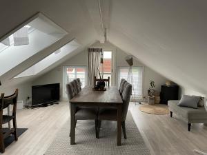 a dining room with a table and chairs in a attic at Victoriagården in Grimstad
