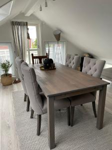 a dining room table with chairs in a living room at Victoriagården in Grimstad