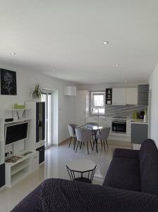a living room and kitchen with a couch and a table at Teo's place in Selca
