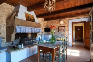 a kitchen with a table and a fireplace in a room at Casale Rosso in Castel San Felice