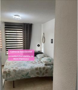 een slaapkamer met twee bedden met een roze bord erop bij Les Logis de Paray Appartement 201 in Paray-le-Monial