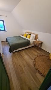 1 dormitorio con 1 cama grande y suelo de madera en Martinus Vendégház, en Tagyon