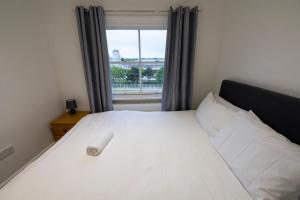 a bedroom with a white bed with a window at Entire Two Double Bedrooms Flat with River Yare View H6 in Great Yarmouth