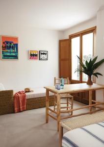 a living room with a table and a bed at Hostal Mar y Sal in Sant Josep de Sa Talaia