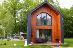 a tiny house with a large window and a playground at Dzika Plaża Stilo in Sasino