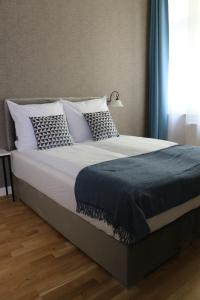 sypialnia z dużym łóżkiem z niebiesko-białymi poduszkami w obiekcie Apartament Żeromskiego 17 - Insel Apartamenty w Świnoujściu