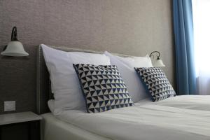 łóżko z białymi poduszkami i 2 lampami w obiekcie Apartament Żeromskiego 17 - Insel Apartamenty w Świnoujściu