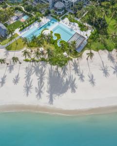 a beach with palm trees and palm trees at Centara Reserve Samui - SHA Plus in Chaweng