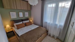 Habitación pequeña con cama y ventana en Apartament Młody Gdańsk - bezpłatny parking, mocne WiFi, dobre połączenie z lotniskiem en Gdansk