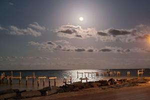 a moon rising over the ocean with a pier at Brand New RV Bay Front in Port Lavaca