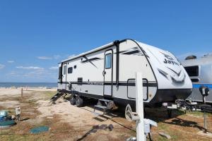 a camper is parked next to the ocean at Brand New RV Bay Front in Port Lavaca