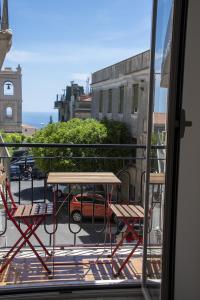 patio ze stołem i krzesłami na balkonie w obiekcie Castalia Apartments & Rooms Duomo Taormina w Taominie
