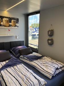 2 camas en una habitación con ventana en Hausboot-LaFe Flensburger Förde en Egernsund