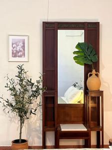 een spiegel in een kamer met een plant bij La Casetta in Muro Leccese