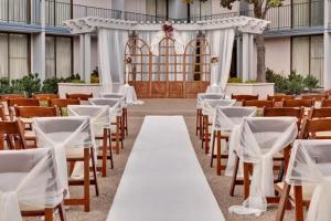 an aisle with white tables and chairs in a building at Holiday Inn Dublin - Pleasanton by IHG in Dublin