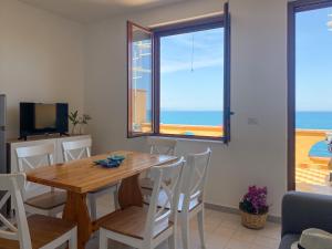 een eetkamer met een tafel en uitzicht op de oceaan bij Jerry Beach house in Agnone Bagni
