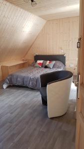a bedroom with a bed and a couch in a attic at la maison des fleurs studio in Le Mont-Dore