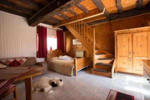 a living room with a bed and a spiral staircase at Maison du bois in Saint-Antoine
