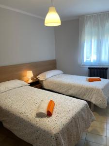 two beds in a small room with a window at Apartamento con estupendas vistas a Coll de Nargó in Coll de Nargó