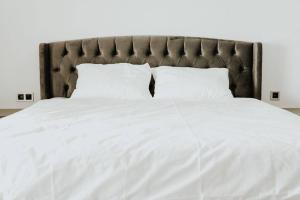 a large white bed with white sheets and pillows at Amazing Seafront new 4 Bedrooms flat with free Wi-Fi in Buyukcekmece