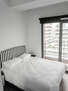 a white bed in a bedroom with a window at Amazing Seafront new 4 Bedrooms flat with free Wi-Fi in Buyukcekmece