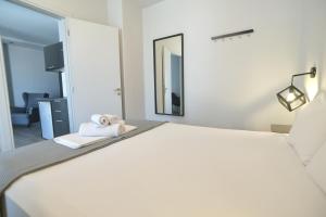 a bedroom with a bed with towels and a mirror at Feel Athens Studios at Monastiraki in Athens