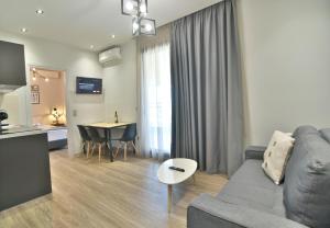 a living room with a gray couch and a table at Feel Athens Studios at Monastiraki in Athens