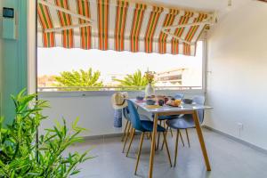 jadalnia ze stołem i krzesłami oraz oknem w obiekcie SELECT'soHOME - Résidence Le Levant - Services hôteliers - Appartement proche plage&commerces avec parking ! - LEV41 w mieście Le Lavandou