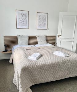 a bedroom with a bed with two towels on it at Hos Martin - Bed and Tee Kitchen - Kontaktløst - Contactless in Sindal