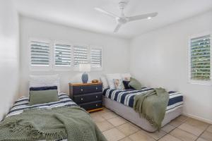 sypialnia z 2 łóżkami, komodą i oknami w obiekcie Homely 2 BR Apt at Coolum Beach w Pool w mieście Coolum Beach