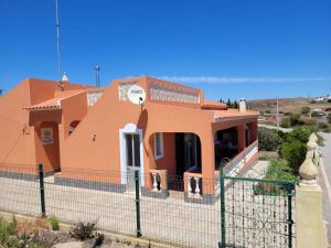 ein großes orangenes Haus mit einem Zaun in der Unterkunft Quinta dos Moledros in Figueira