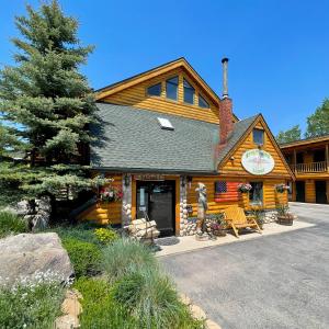 una cabaña de madera con un hombre parado fuera de ella en Spirit Lake Lodge, en Grand Lake