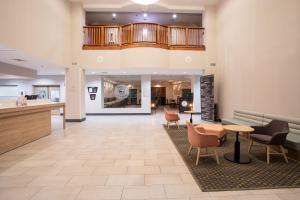 a lobby of a hospital with chairs and tables at Holiday Inn & Suites Goodyear - West Phoenix Area by IHG in Goodyear