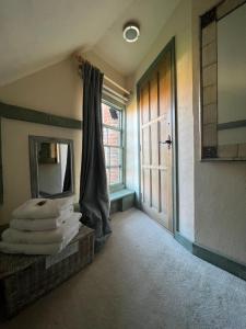 a room with a mirror and a door and towels at The Tea House in Rye