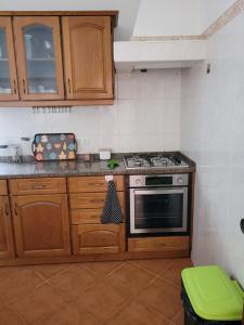 eine Küche mit Holzschränken und einem Herd mit Backofen in der Unterkunft Quinta dos Moledros in Figueira