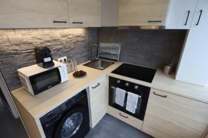 uma pequena cozinha com micro-ondas e máquina de lavar louça em Design & Original - Appart'Hôtel Mont Blanc em Cachan