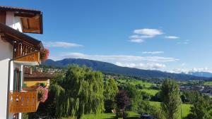 a view from the balcony of a house with trees and mountains at La Montanina Hotel in Val di Non in Malosco +57 photos