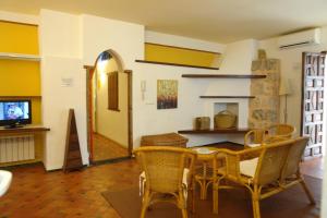 une salle à manger avec une table, des chaises et une télévision dans l'établissement Casa Rural Plaza De Santa Maria, à Cazorla