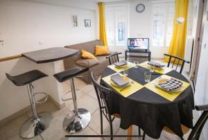 a living room with a table and a couch at LE BON'APPART proche INSEAD in Fontainebleau +6 photos