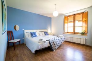 1 dormitorio azul con 1 cama y 1 silla en Apartamentos Ribera del Duero Las Escuelas, en Vadocondes