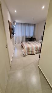a small bedroom with a bed and a window at Flat Hotel América Campos Pelinca 301 in Campos dos Goytacazes