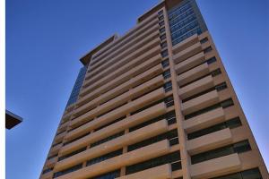 un edificio alto con un cielo azul en el fondo en Flat Hotel América Campos Pelinca 301 en Campos dos Goytacazes